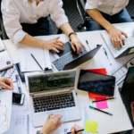 project team planning a business website development timeline around laptops in an office