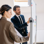 propietario de una pyme y responsable de marketing preparando el plan de marketing digital del año siguiente en una pizarra